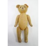 A late 19th/early 20th century golden plush Teddy Bear with button eyes, and moveable limbs &