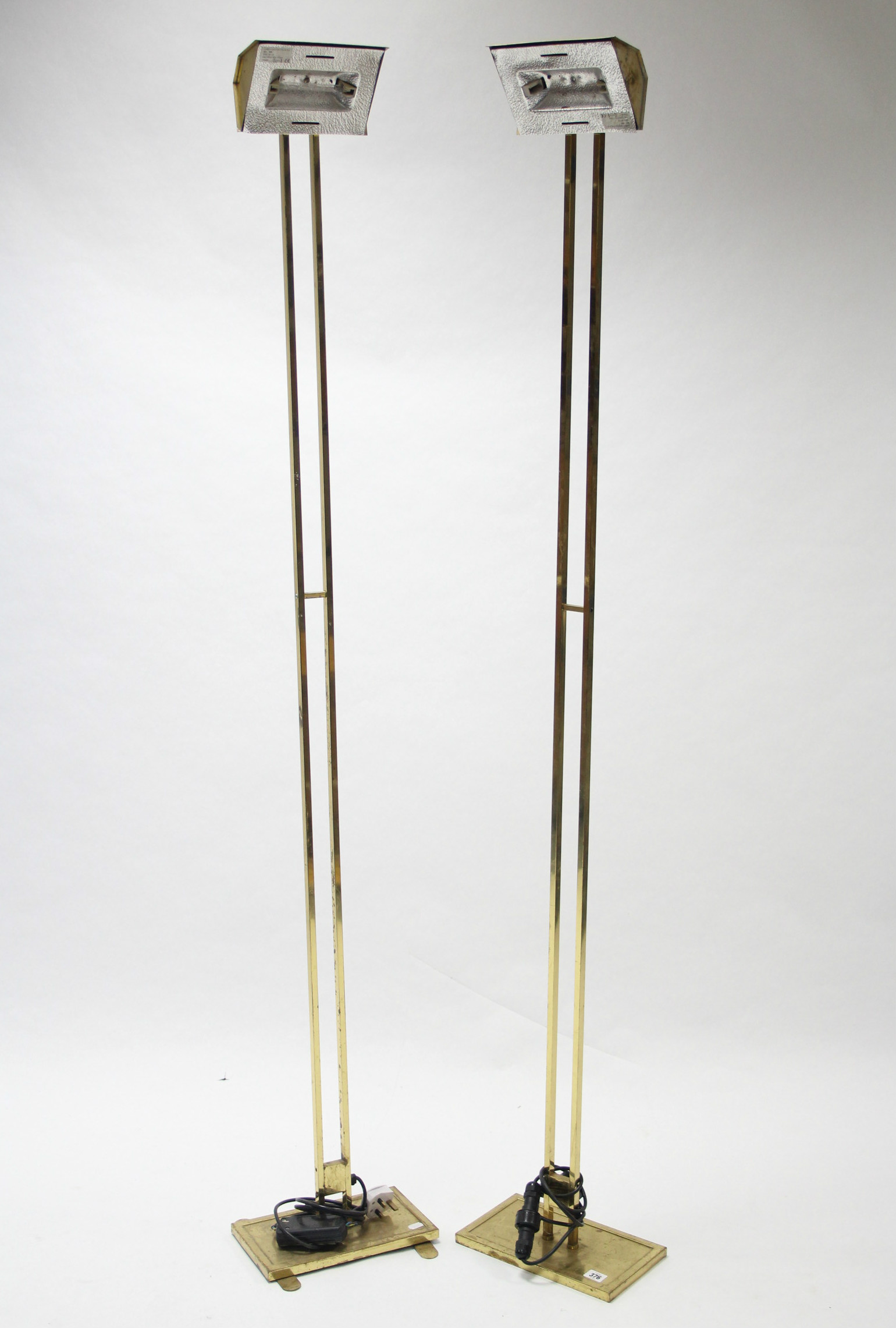 A pair of brass-finish industrial anglepoise standard lamps, 70” high.