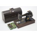 A Singer hand sewing machine with oak carrying case.