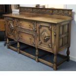 AN EARLY 20th CENTURY CARVED OAK SIDEBOARD IN THE JACOBEAN STYLE with low-stage panel back, fitted