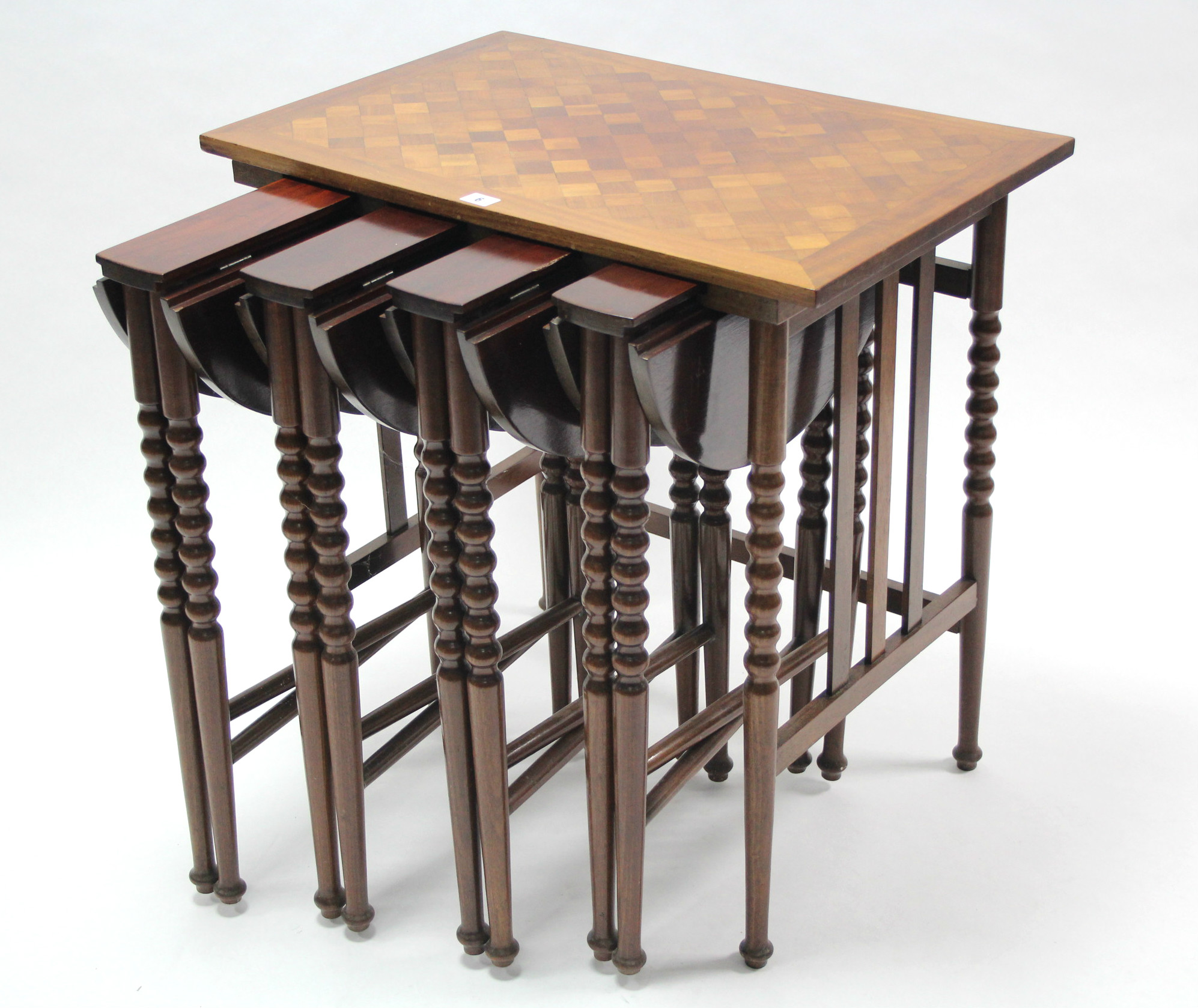 A mahogany nest of five occasional tables (four under one), the smaller tables with circular drop