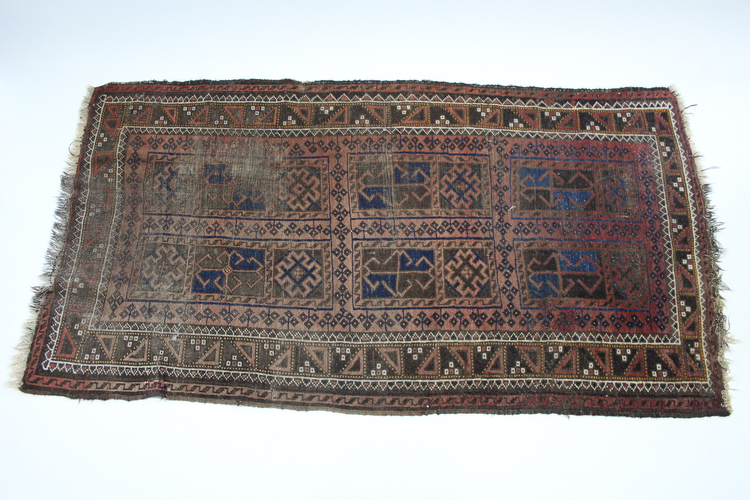 A 19th century Afghan rug of crimson ground, the centre with six rectangular geometric panels &