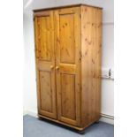 A pine wardrobe enclosed by pair of fielded panel doors & on bun feet, 37¾" wide x 72¼" high.