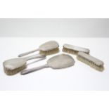 A George VI silver-backed five piece dressing table set comprising a hand mirror, pair of clothes, &