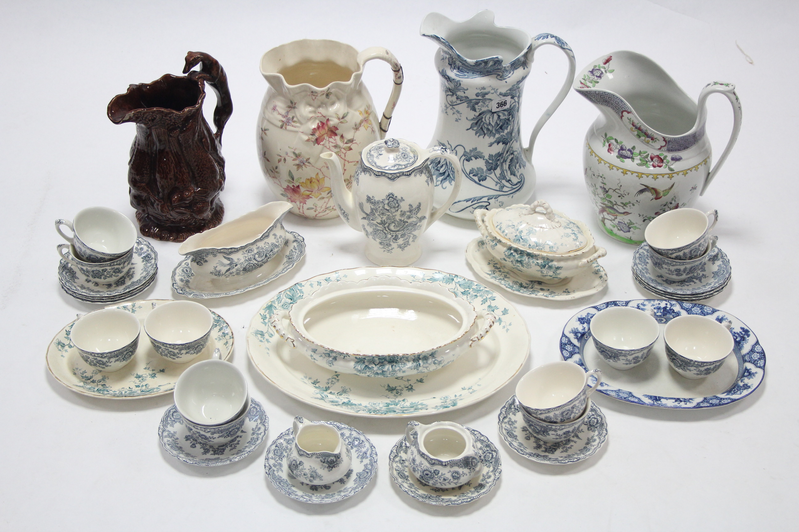 Three floral decorated toilet jugs; a brown glazed pottery water jug; a Crown Ducal ware “Bristol”