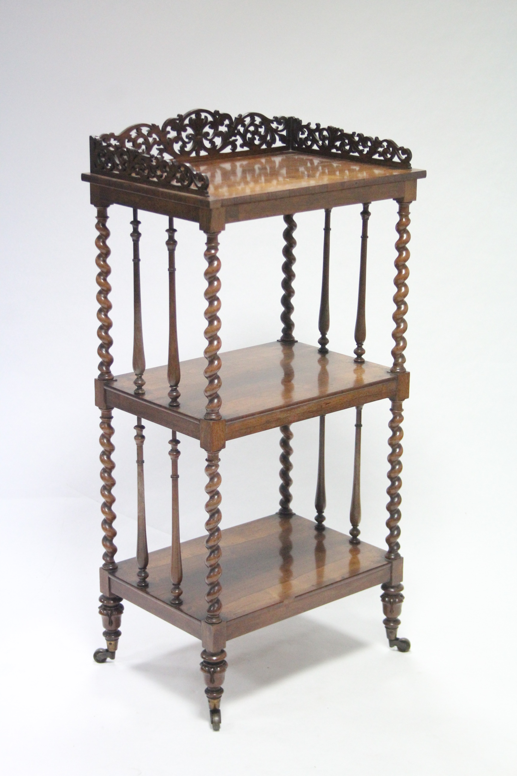 A mid-19th century rosewood three tier rectangular whatnot with carved pierced tray-top, barley-