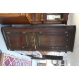 An 18th century oak standing corner cupboard with three shaped shelves to the top enclosed by