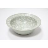 A Chinese porcelain deep bowl with wide rim, of pale celadon ground with thickly-painted white