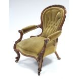 A Victorian carved mahogany spoon-back armchair with padded seat & arms & buttoned back