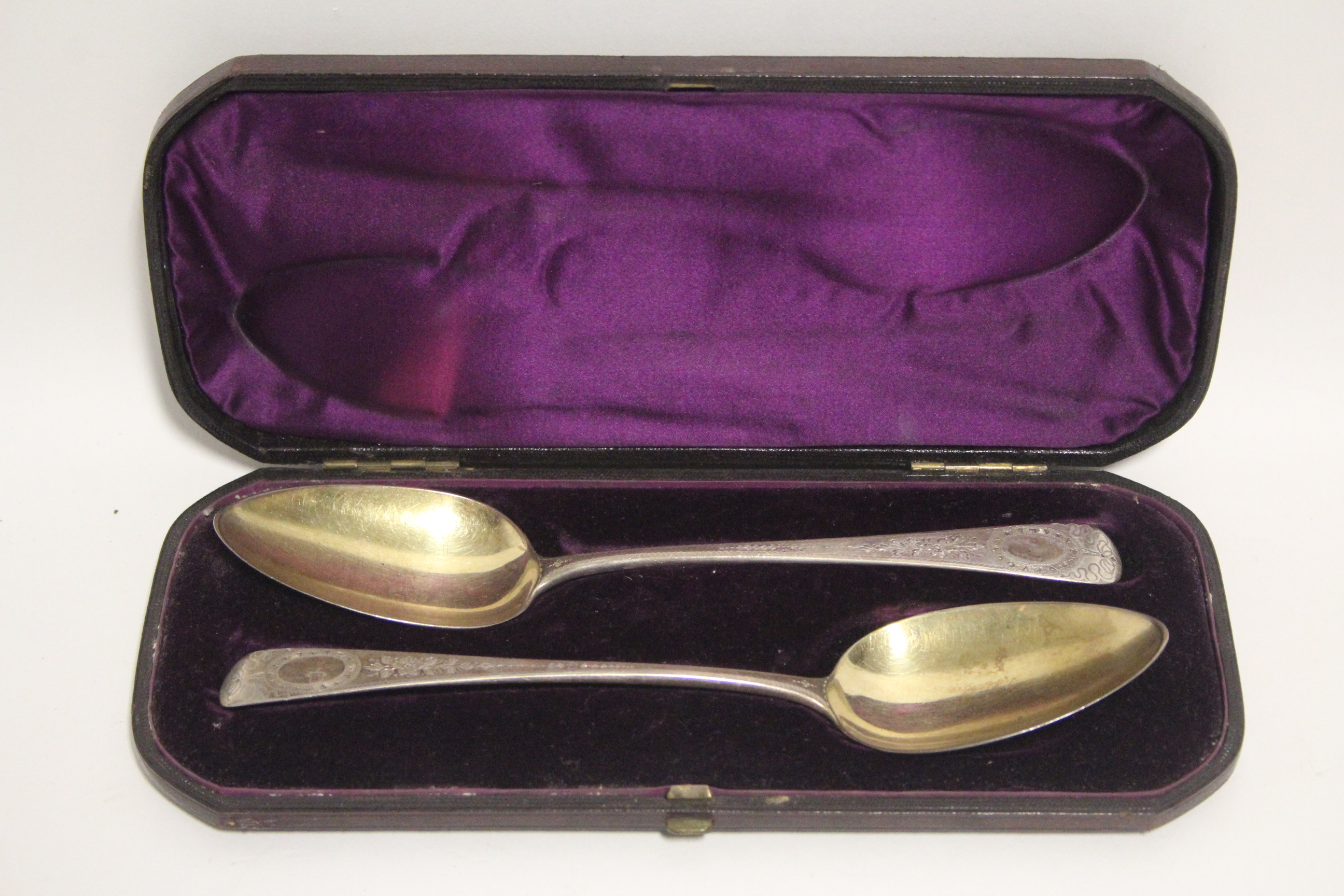 A pair of George III Old English table spoons with later engraved floral decoration & parcel-gilt