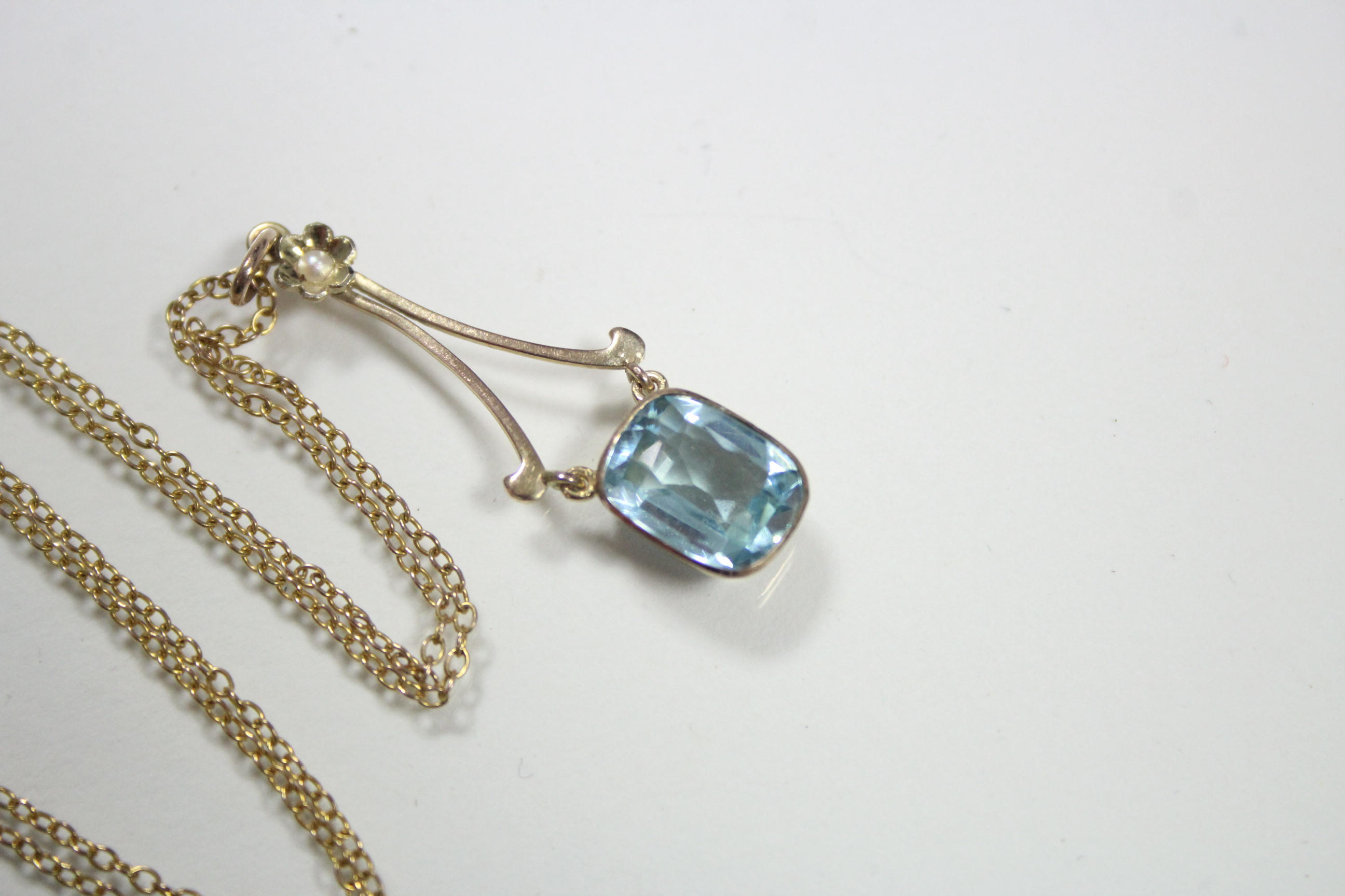 An aquamarine pendant, the articulated cushion-shaped stone set to 9ct. gold mounts, with seed pearl - Image 2 of 3