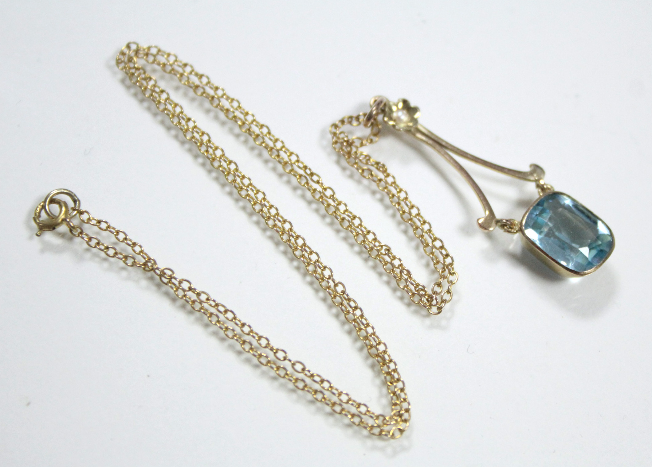 An aquamarine pendant, the articulated cushion-shaped stone set to 9ct. gold mounts, with seed pearl