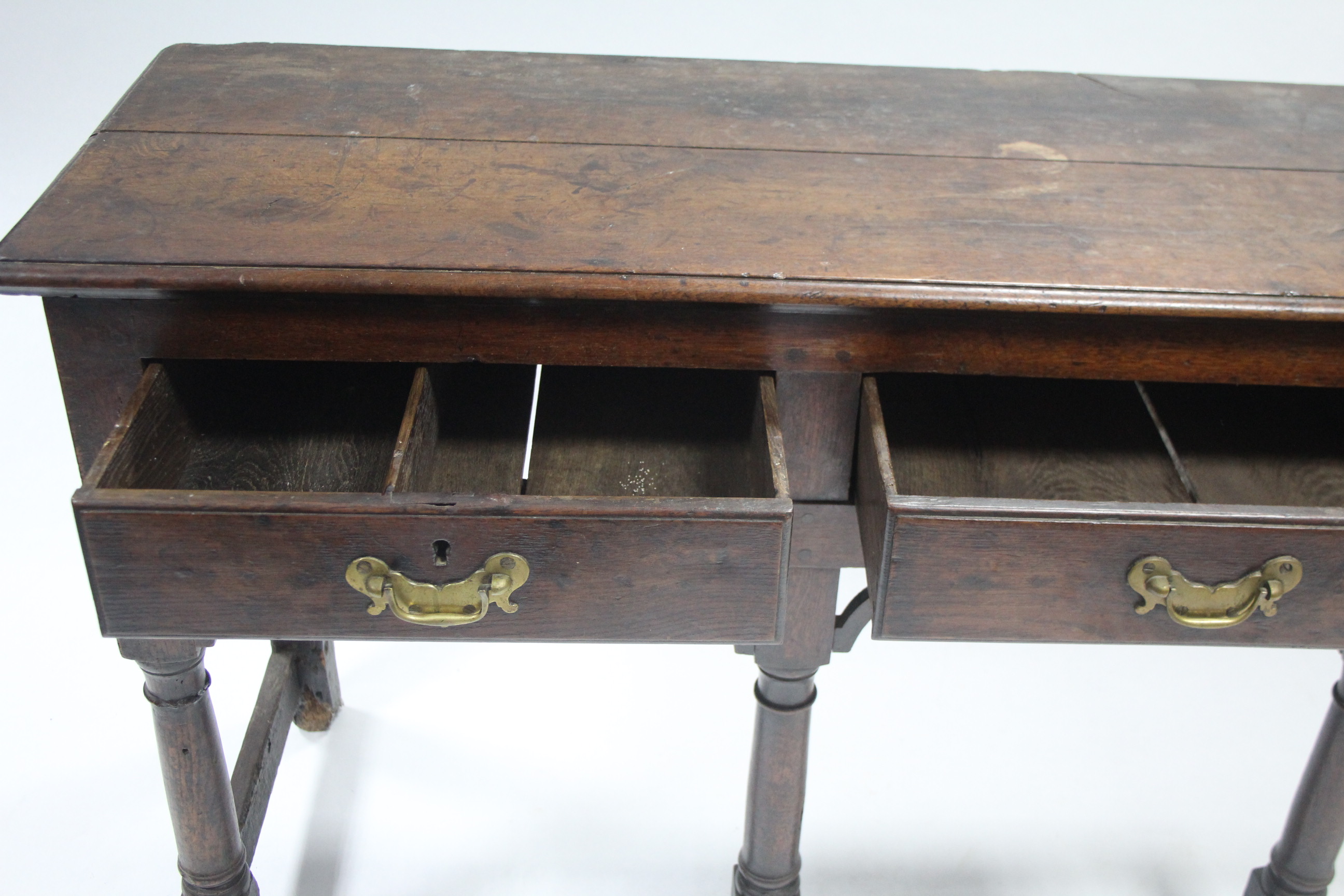 AN 18th century OAK DRESSER BASE, fitted three drawers with shaped brass handles, & on turned - Image 2 of 3