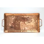 A Newlyn copper oblong two-handled tray by JOHN PEARSON, with raised border & embossed scroll