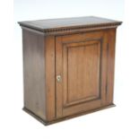 A 19th century mahogany small hanging wall cabinet, enclosed by fielded panel door with shield-