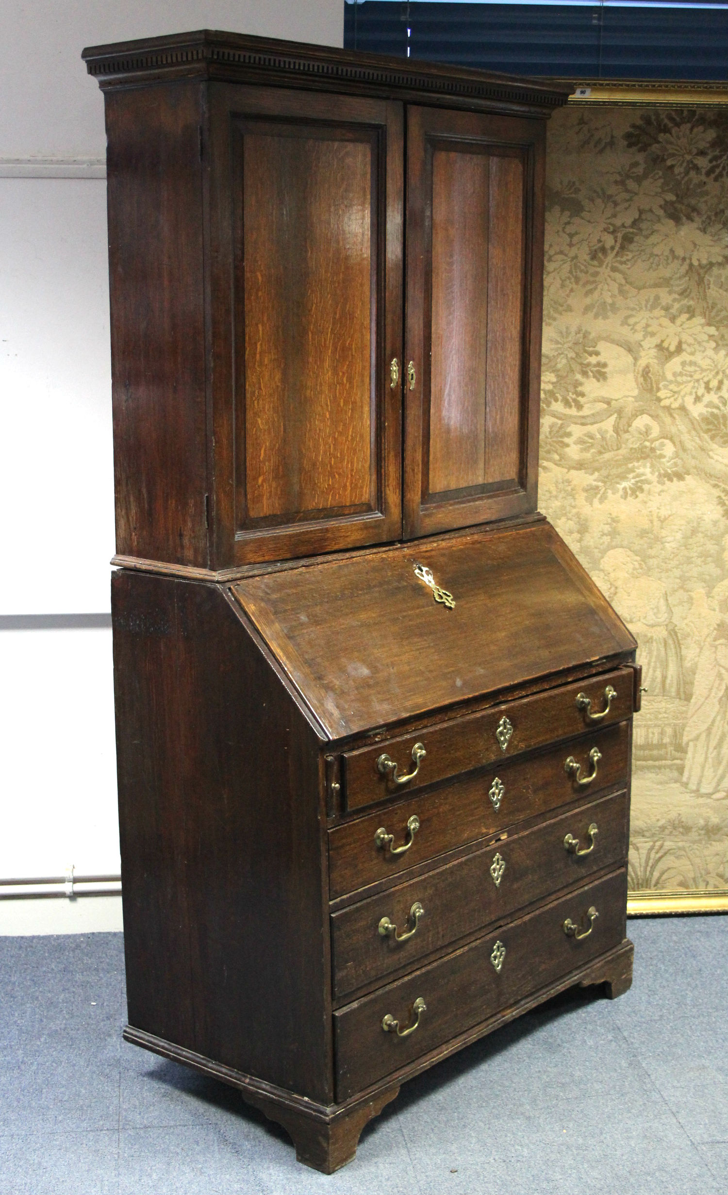 A late 18th century oak bureau-bookcase with adjustable shelves enclosed by a pair of panel doors,