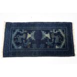 A small Chinese rug of deep blue ground, decorated with birds, trees, & deer; 43” x 22”.