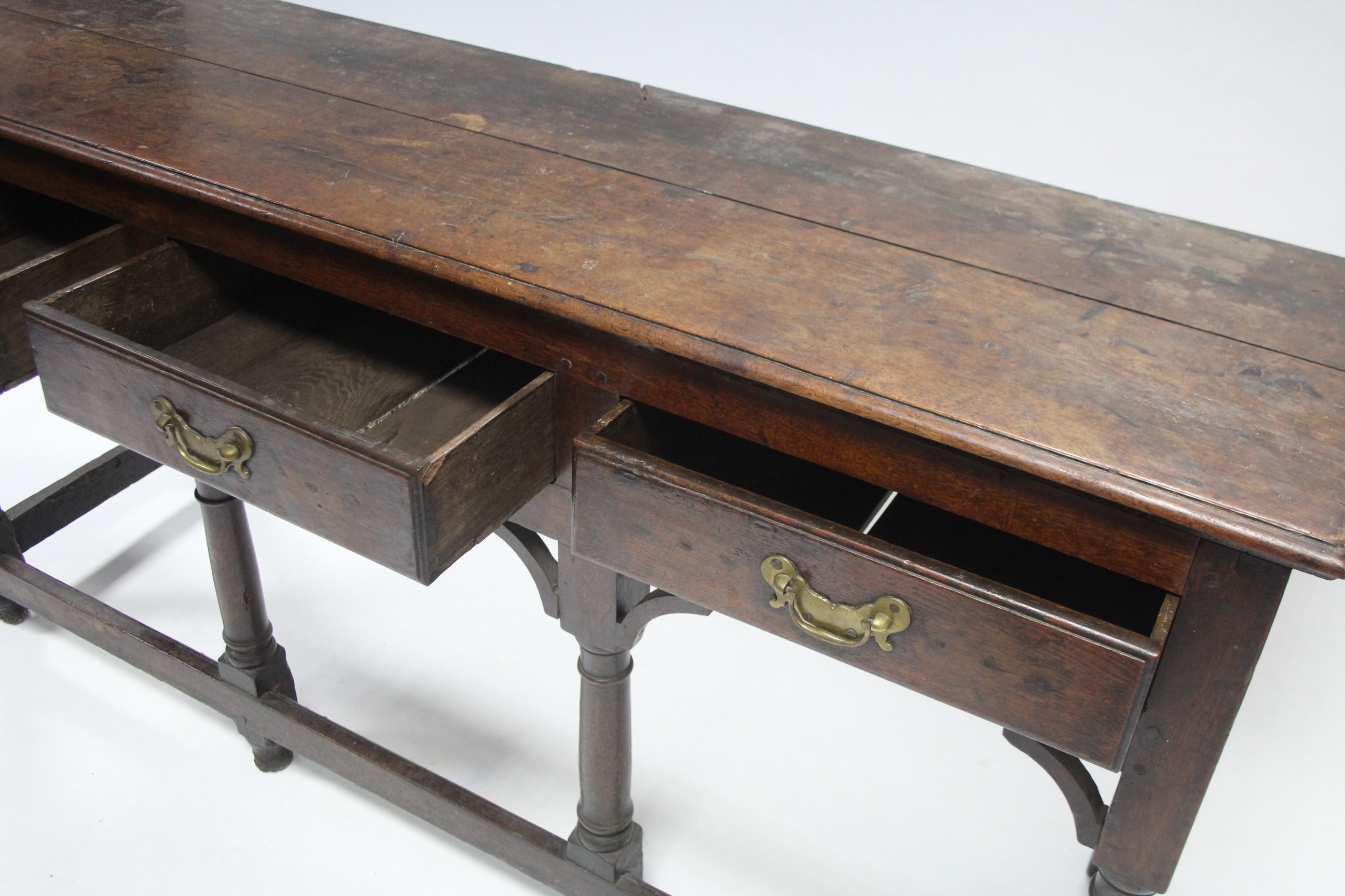 AN 18th century OAK DRESSER BASE, fitted three drawers with shaped brass handles, & on turned - Image 3 of 3