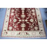 An Indian carpet of burgundy ground, with all-over stylised floral pattern ivory & pale green; 9' 4"