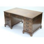 A MAHOGANY PEDESTAL DESK, the rectangular top inset gilt-tooled tan leather, fitted nine drawers
