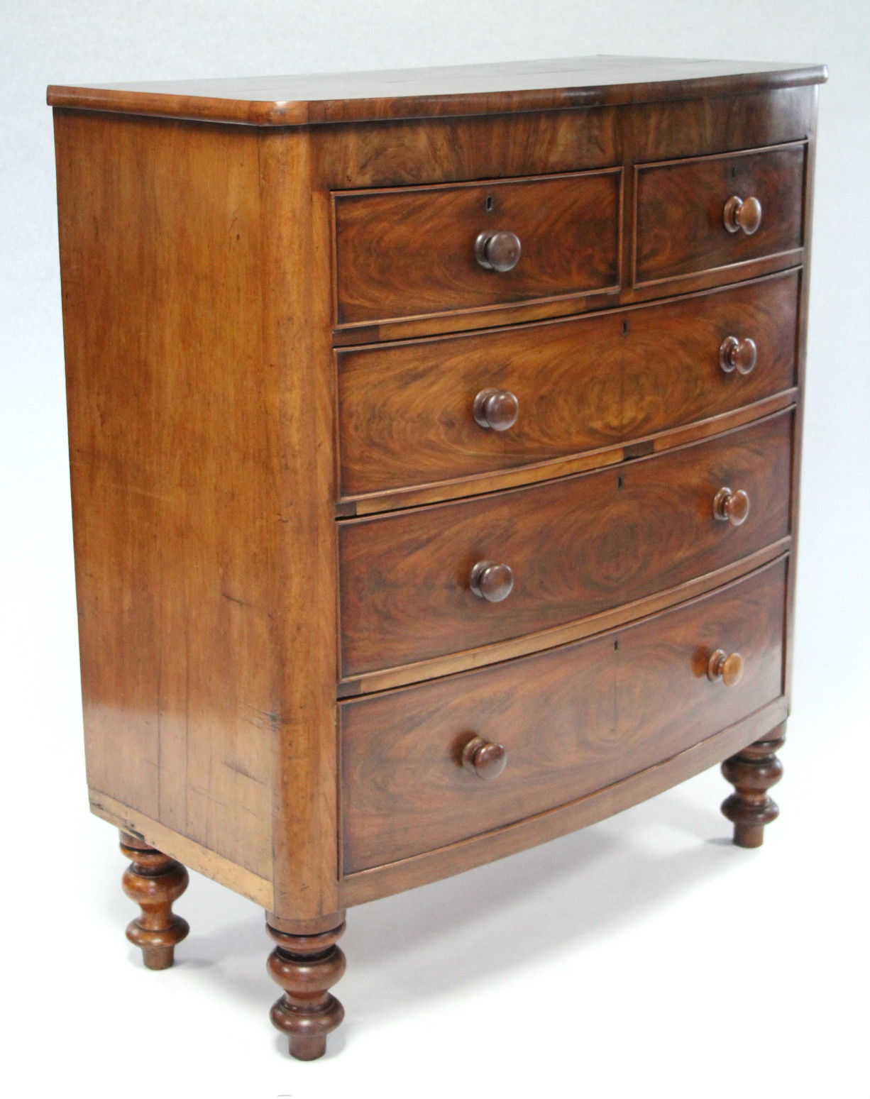 A Victorian figured mahogany bow-front chest fitted two short & three long graduated drawers with