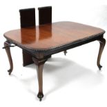 A late 19th/early 20th century mahogany extending dining table with wind-out action, the top with