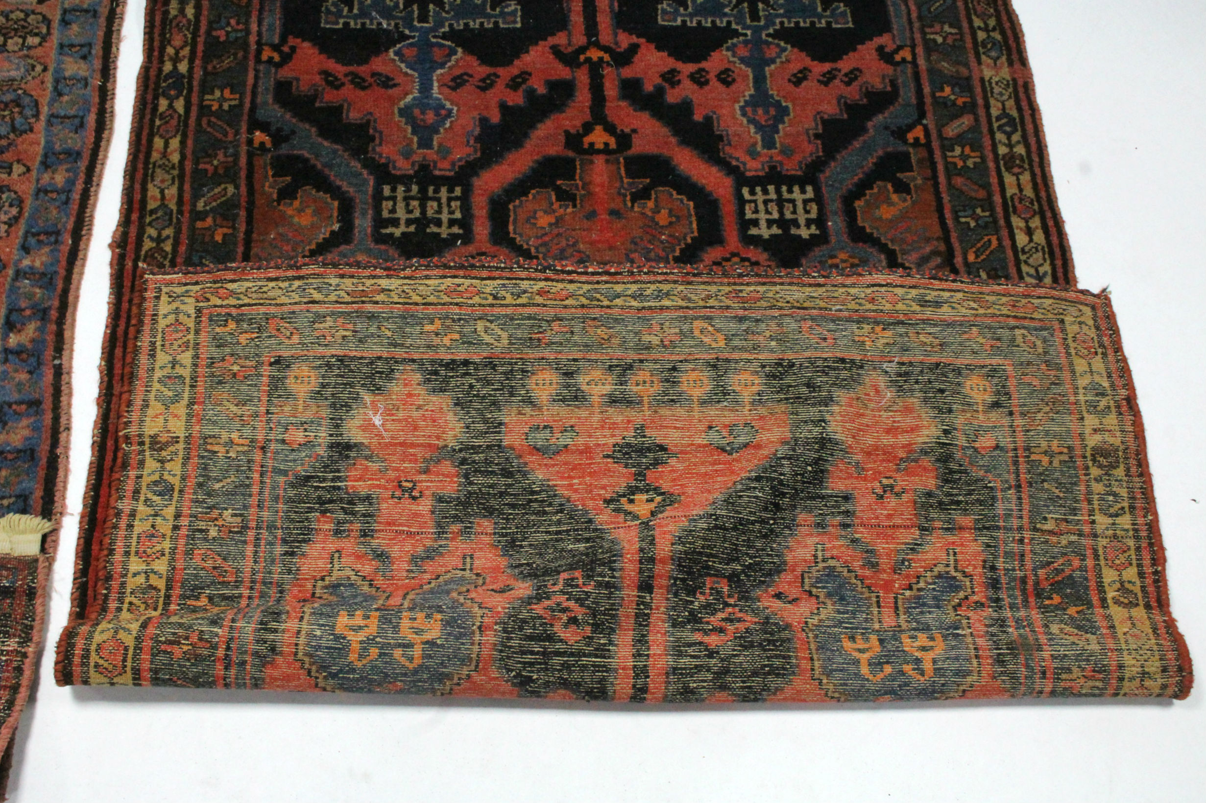 A Persian rug of dark blue ground, pink, blue, & ivory figured with abstract motifs within narrow - Image 3 of 3