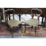 A set of four Victorian carved rosewood dining chairs with shaped open backs, padded seats, & on