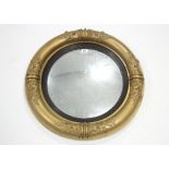 A late regency convex wall mirror in gilt gesso frame with foliate border (later painted gold);