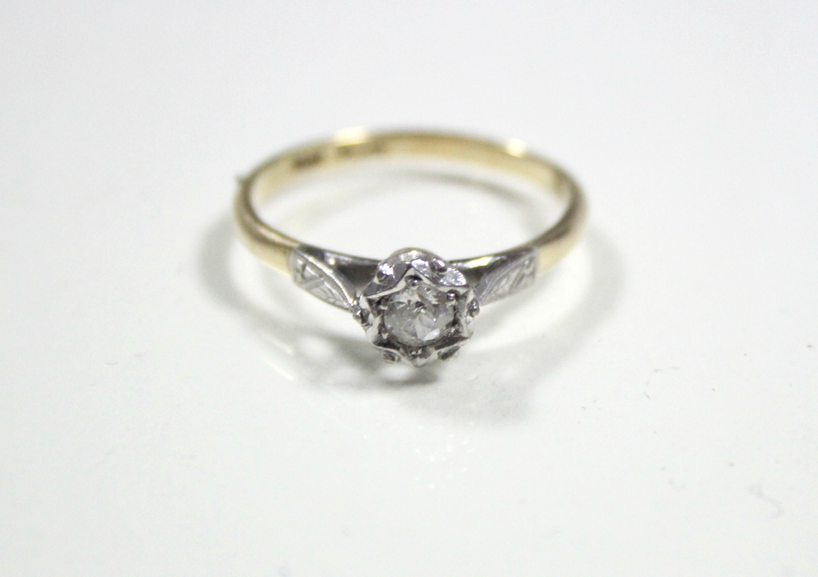 An 18ct. gold & platinum ring set single diamond of approximately 0.25 carat to a star-shaped