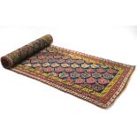 A PERSIAN RUNNER of dark blue ground, with repeating multi-coloured paisley design within mustard,