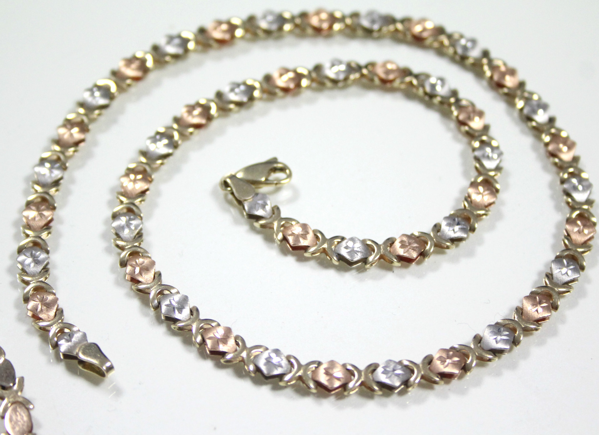 A 14K articulated necklace of alternating rose-pink & white engraved small oval panels, 17½" long (