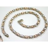 A 14K articulated necklace of alternating rose-pink & white engraved small oval panels, 17½" long (