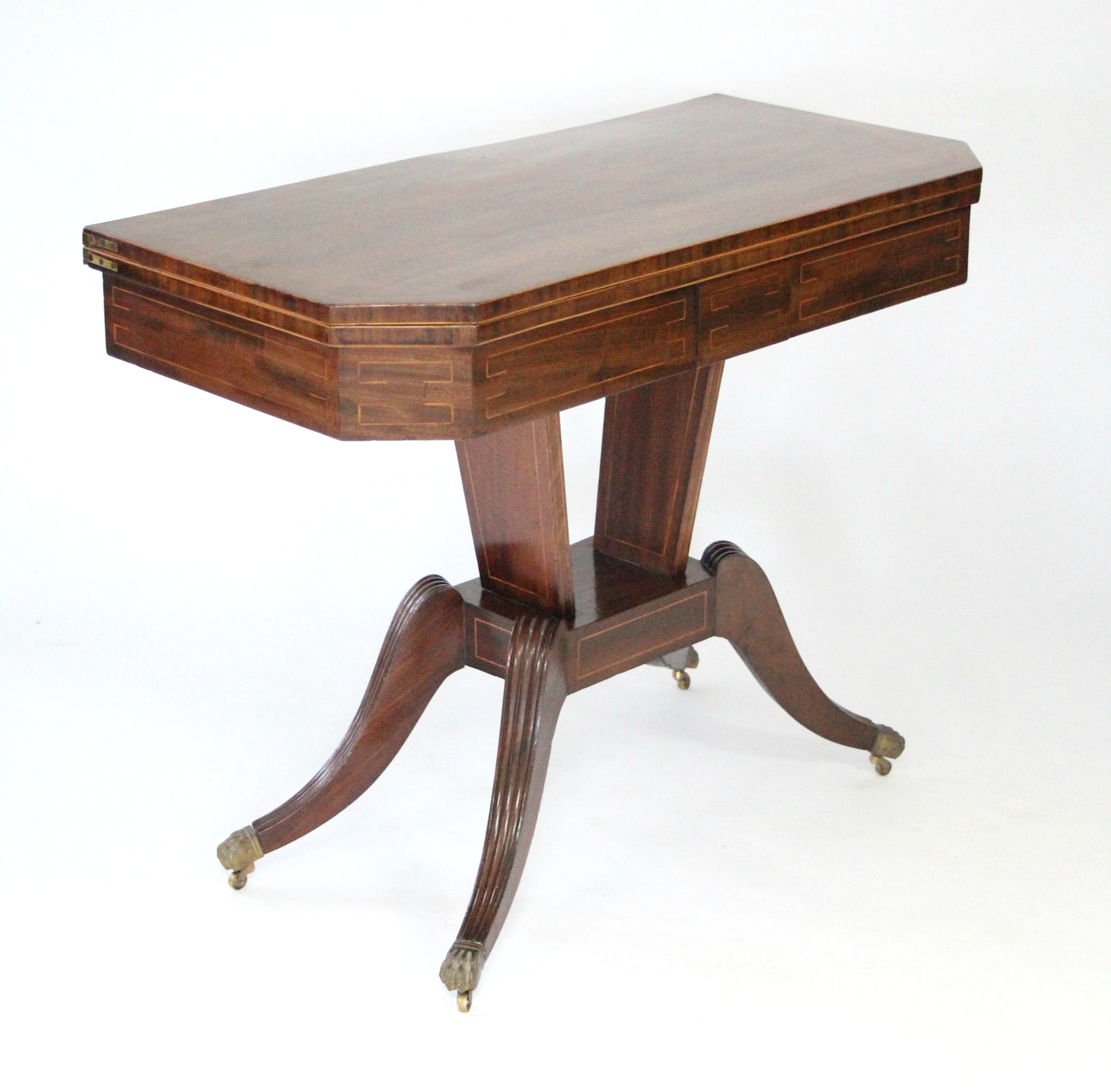 A REGENCY INLAID-MAHOGANY CARD TABLE, the rectangular fold-over top having canted corners with