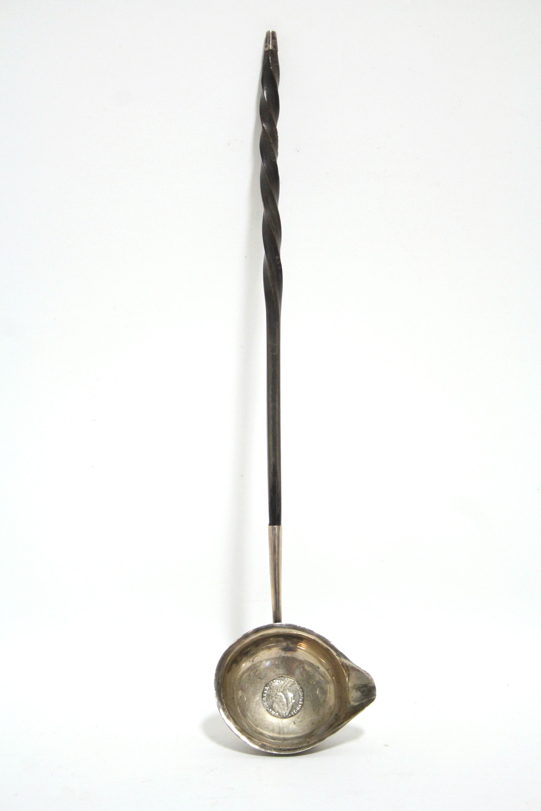 A George III punch ladle, the oval lipped bowl inset George II sixpence, with long whalebone twist