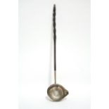A George III punch ladle, the oval lipped bowl inset George II sixpence, with long whalebone twist
