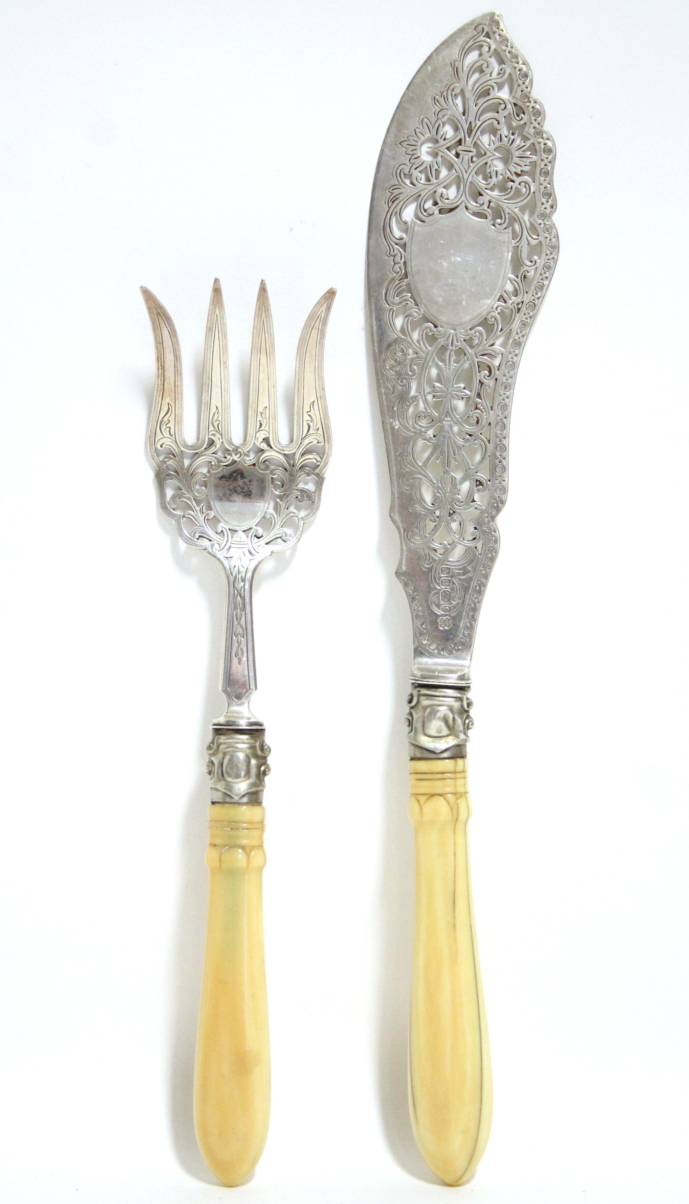 A pair of Victorian pierced & engraved fish servers with carved ivory handles; Sheffield 1869, by