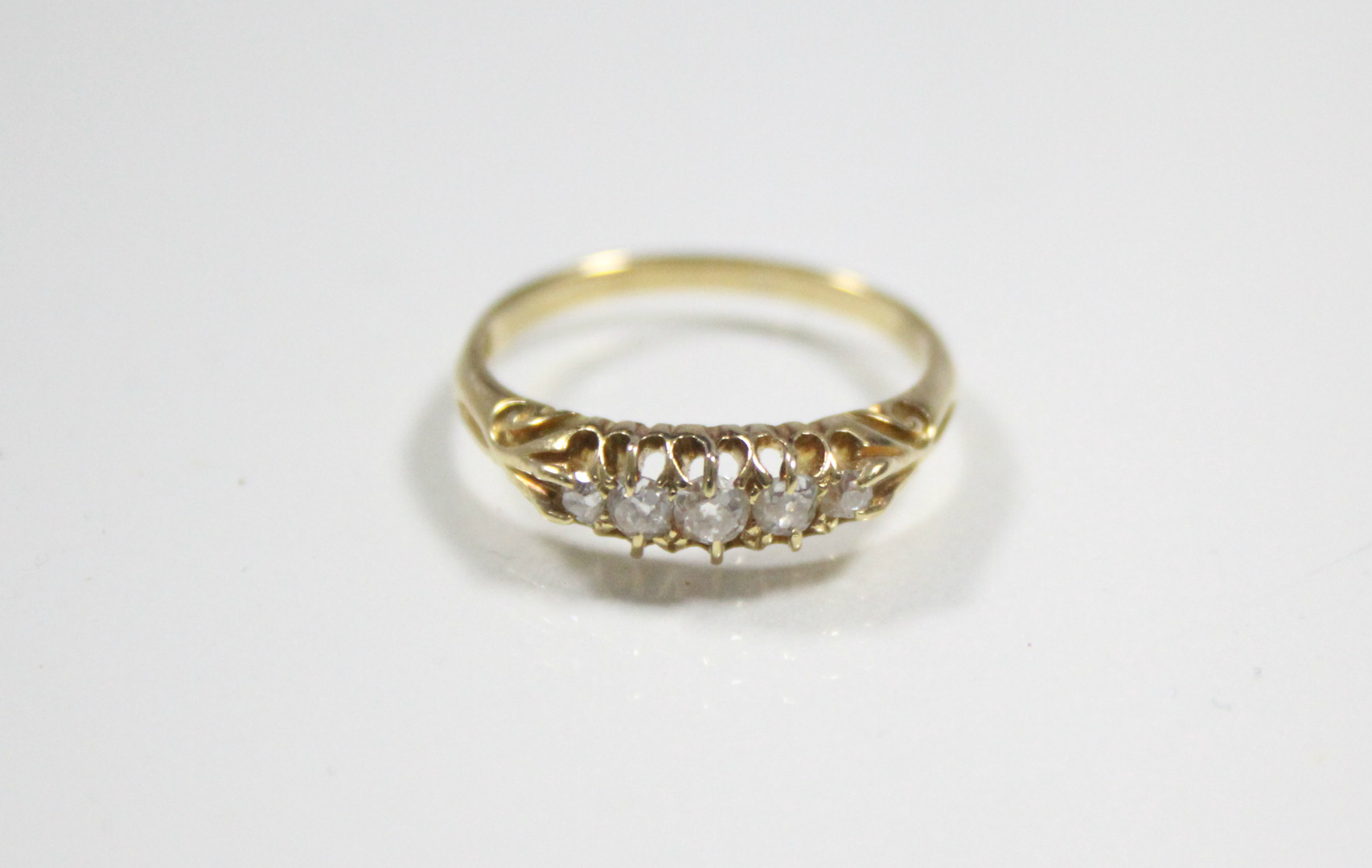 An 18ct. gold ring set row of five small graduated diamonds.