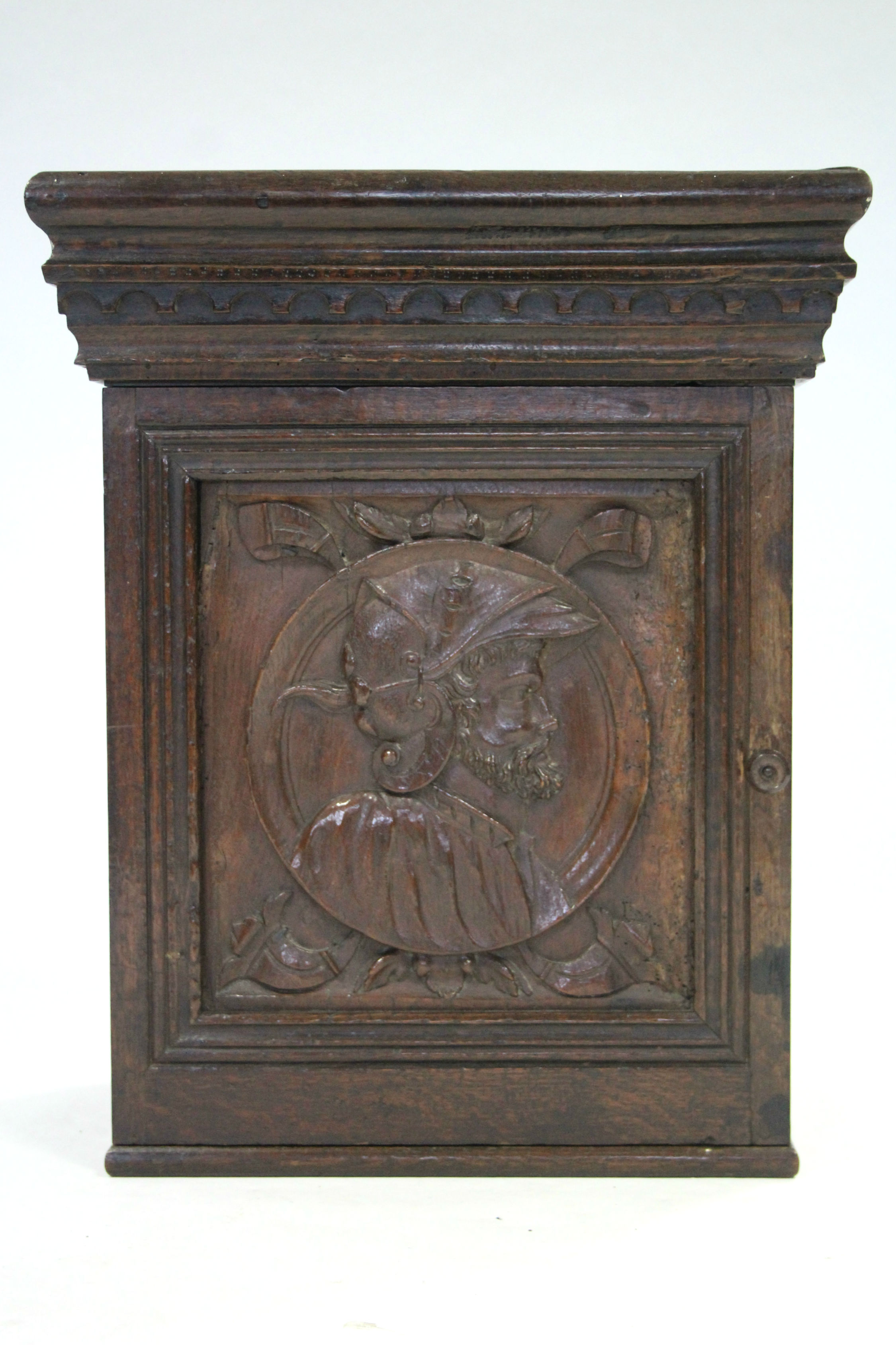 A 17th century style carved walnut & oak small cabinet enclosed by panel door with decoration of a