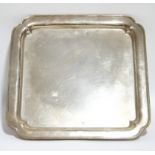A George V heavy-gauge square tray with re-entrant corners & moulded rim to the raised border, on