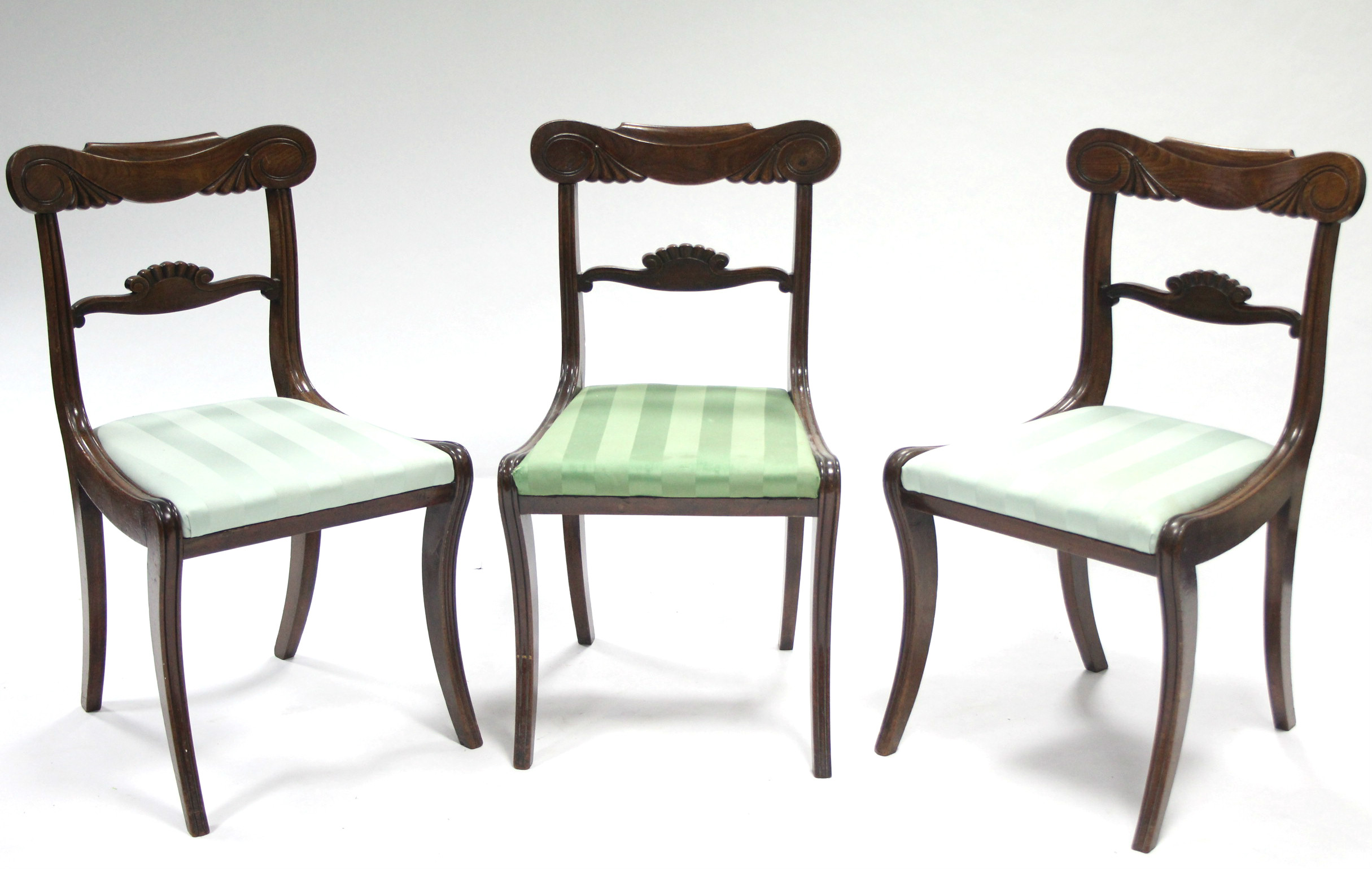 A set of three regency mahogany dining chairs with cared top & centre rails, padded drop-in seats