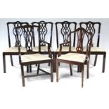 A set of four Chippendale style mahogany dining chairs with pierced splat backs, padded drop-in