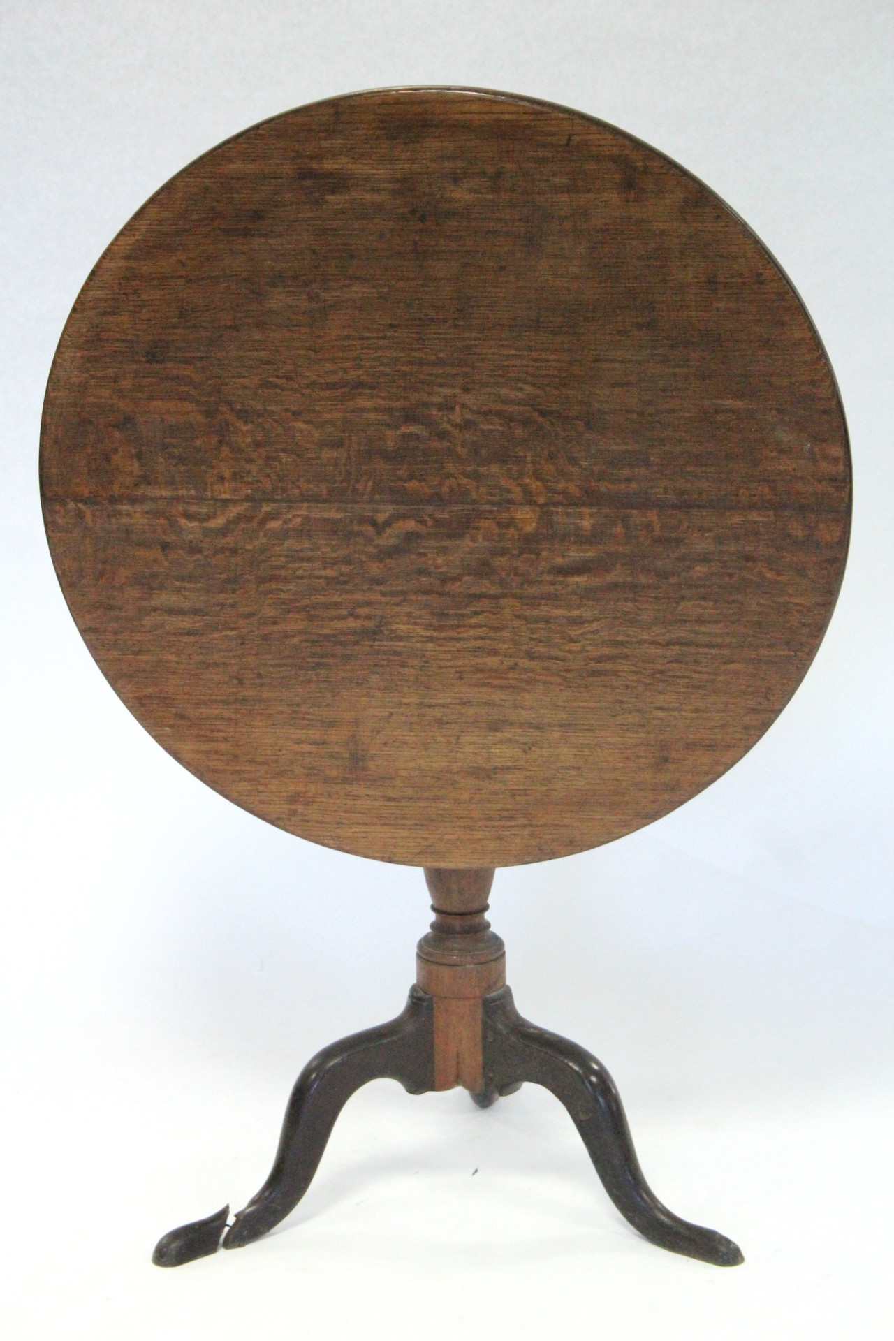 An 18th century oak tripod table, the circular tilt-top on vase-turned centre column & three