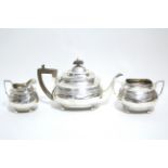 A George II teapot of compressed oblong form with reeded bands, on four ball feet, London 1810, by