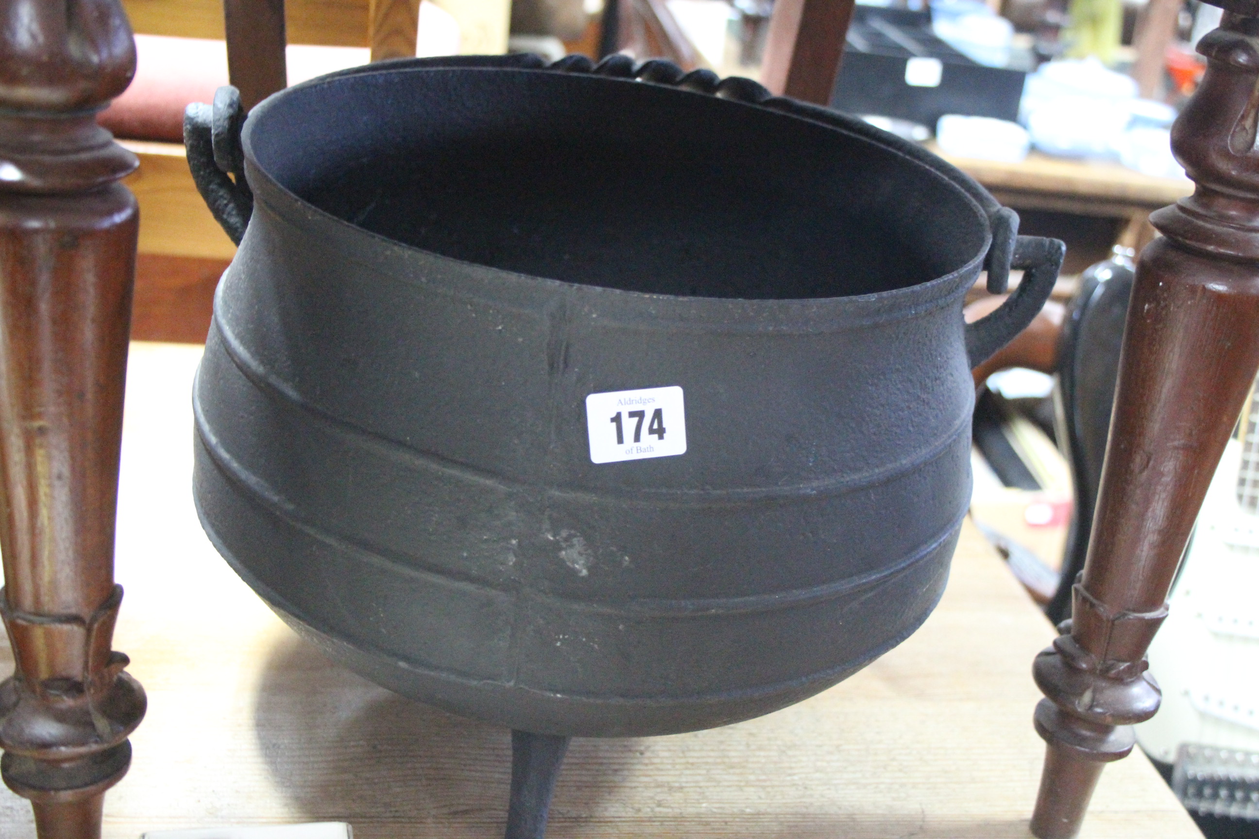 A cast-iron cauldron, 11¼” diam.; an Eastern brass engraved circular tray; a glass terrarium;