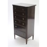 A reproduction mahogany small upright chest, fitted six long graduated drawers with brass ring