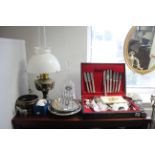 A part canteen of cutlery; a table lamp; an oil lamp; various items of glassware, etc.