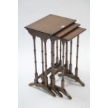 A mahogany nest of three rectangular occasional tables, each on four spider-turned legs.