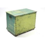 A green painted deal storage trunk with hinged lift-lid, wrought-iron side handles & on plinth