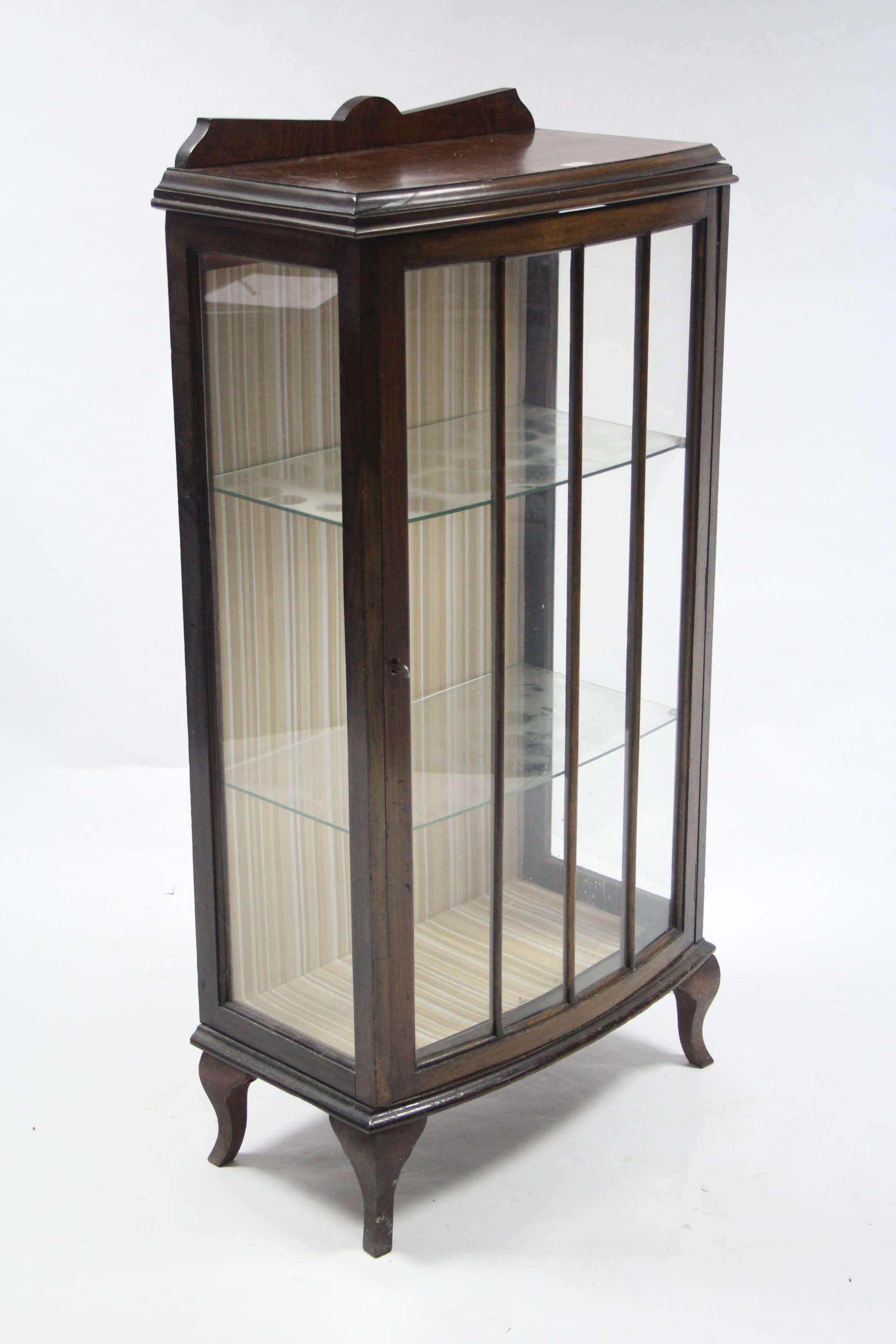 A Walnut small bow-front china display cabinet fitted two plate-glass shelves enclosed by glazed